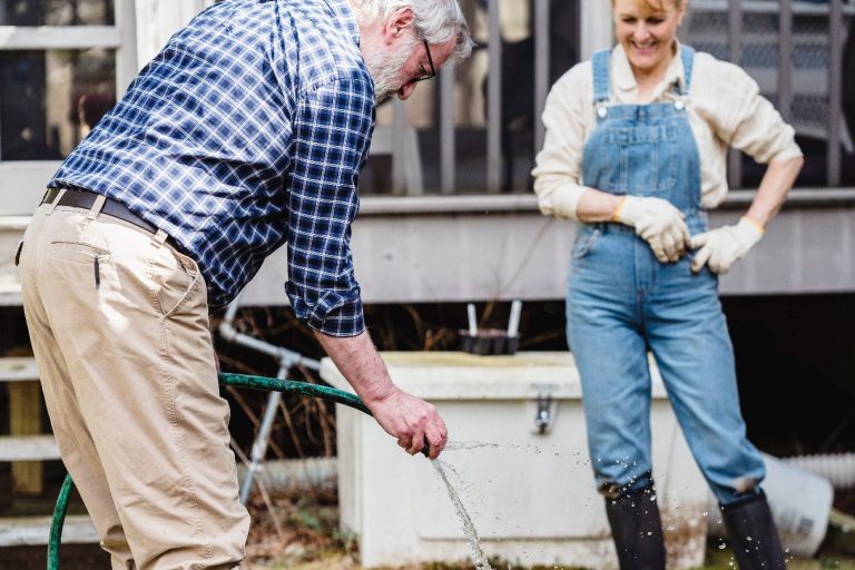 un homme et une femme utilisant de l'eau de pluie pour arroser leur jardin